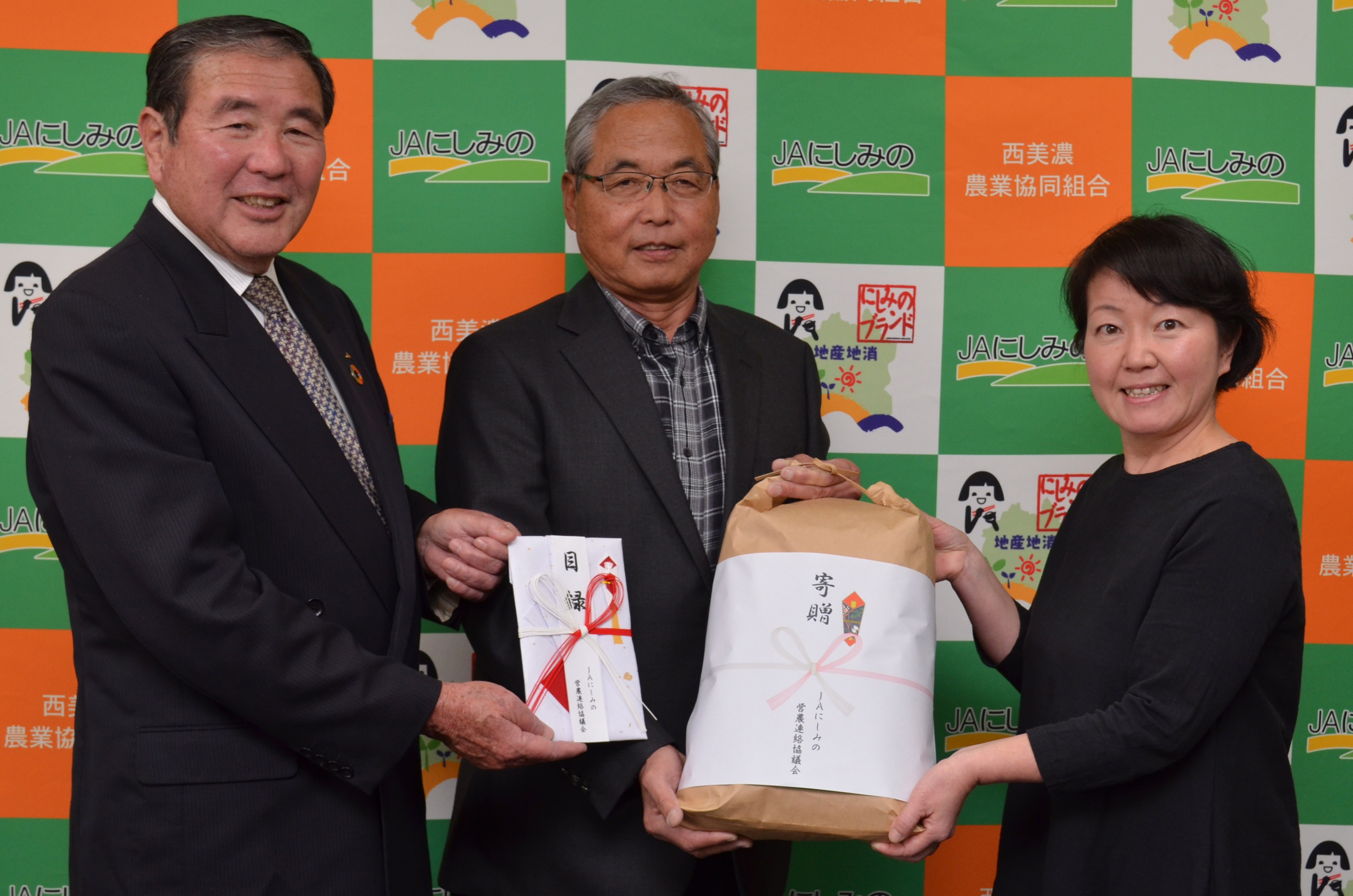 目録と米袋を手に左から小林組合長、杉野会長、松村さん